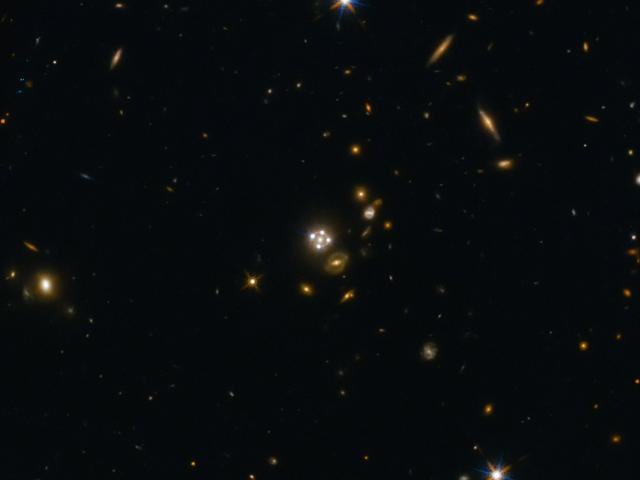 Four Quasar Images Surround a Galaxy Lens