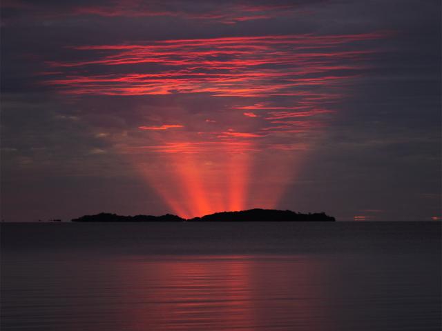 Red Crepuscular Rays from an Eclipse