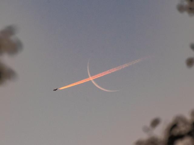 Plane Crossing Crescent Moon