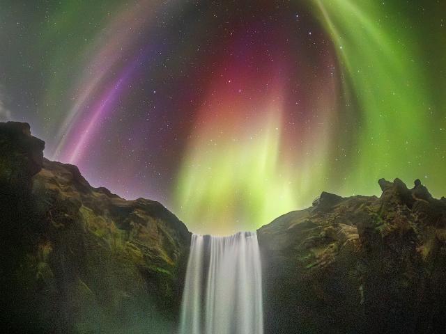 Colorful Aurora over an Icelandic Waterfall